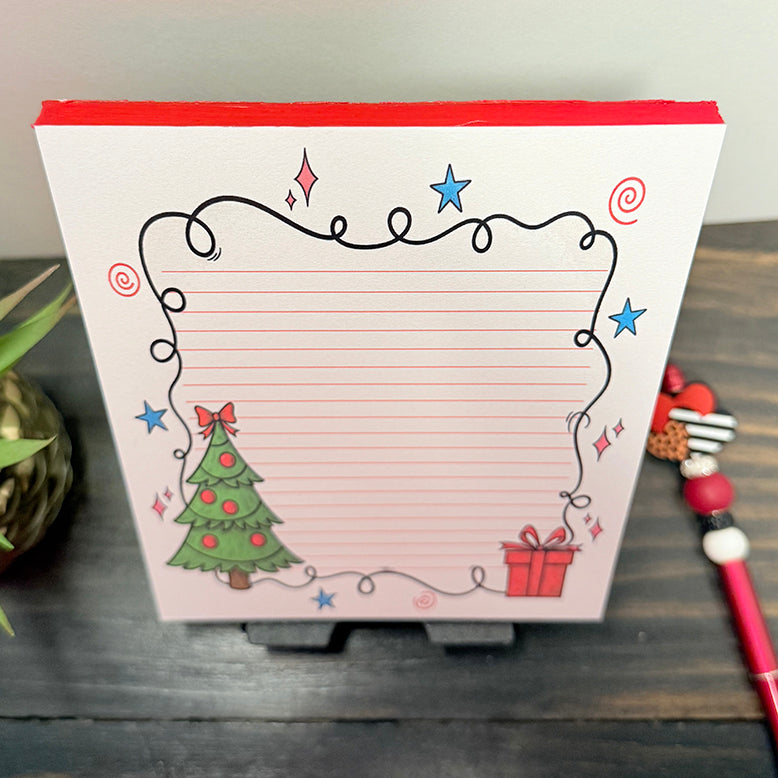 Christmas 5x7 lined notepad with festive tree and gift design, red page edges, and decorative light border β holiday stationery pad for notes and lists.