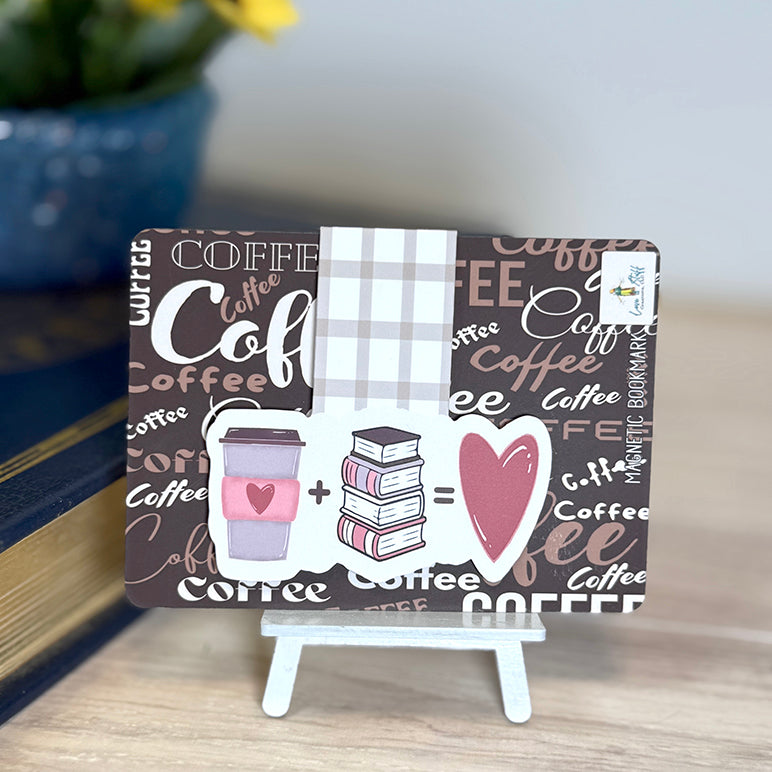 “Coffee + books = love magnetic bookmark displayed on a coffee-themed backing card on a small easel.”