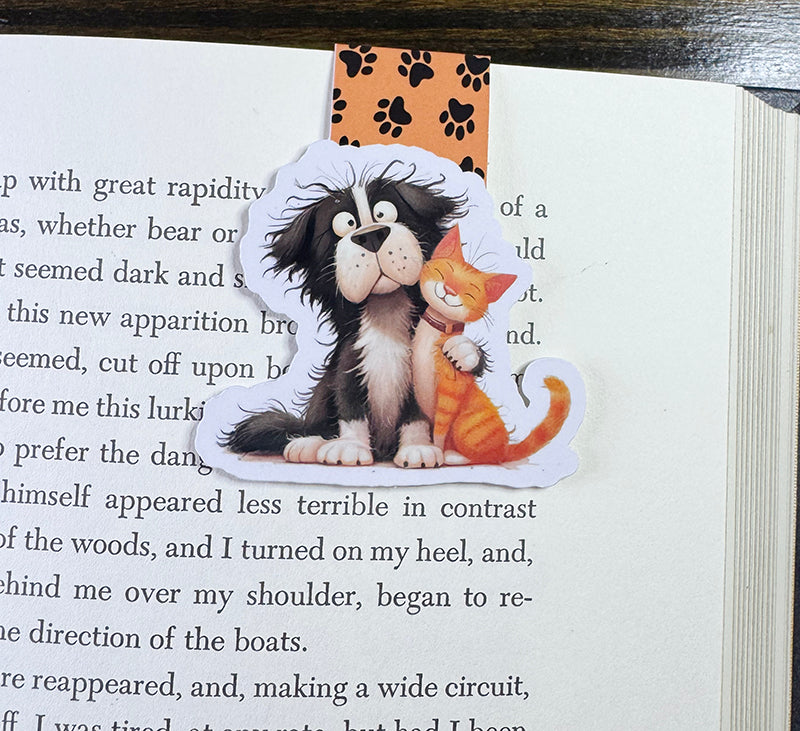 Magnetic bookmark with cute black dog and orange tabby cat hugging, on paw print background