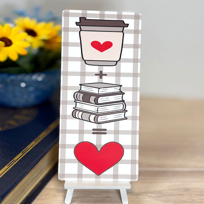 “Coffee + books = love classic bookmark displayed upright with plaid background and bold red heart design.”
