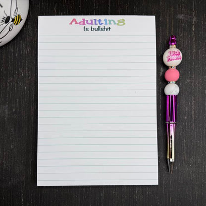 5x7 funny notepad with the phrase “Adulting Is Bullshit” at the top, lined pages, 50 sheets – part of the Notions notepad collection.