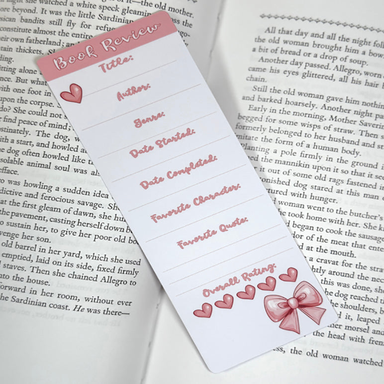 “Book review classic bookmark with pink bow design placed on open book pages, showing fillable sections for reviewing a book.”