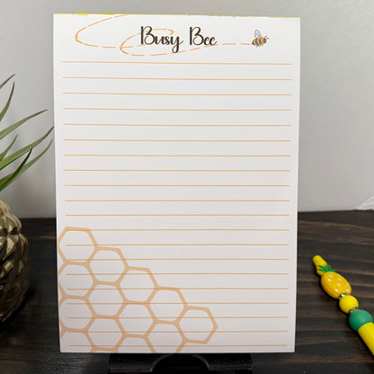 5x7 Busy Bee notepad with lined pages, bee illustration, and honeycomb corner design – cute golden stationery for notes and daily lists.