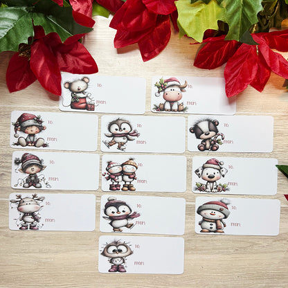 Flat lay of multiple soft-touch Christmas gift tags with different festive characters including penguins, snowmen, elves, and reindeer.