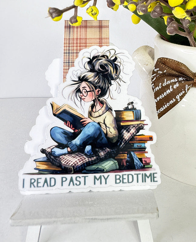 Magnetic bookmark with girl reading past bedtime, surrounded by books and pillows, with plaid tab
