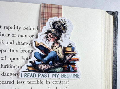 Magnetic bookmark with girl reading past bedtime, surrounded by books and pillows, with plaid tab
