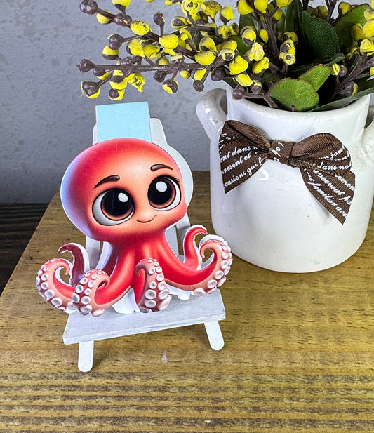 “Cute red octopus magnetic bookmark with big eyes clipped to a book page”