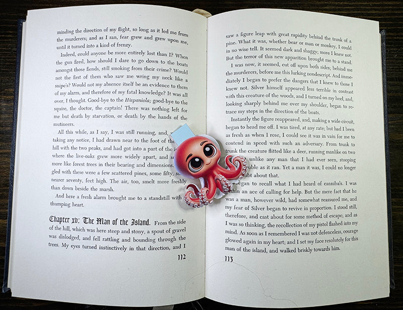 “Cute red octopus magnetic bookmark with big eyes clipped to a book page”