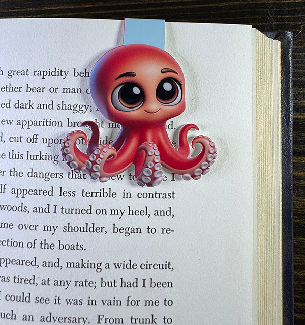“Cute red octopus magnetic bookmark with big eyes clipped to a book page”