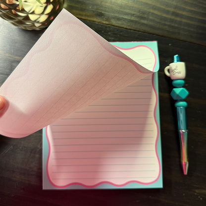 Close-up of a single sheet being lifted from the Pink Bow Notes Notepad, showing the tear-off design and pink scalloped border detail.