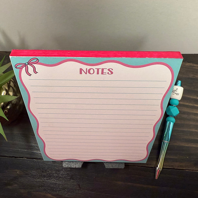 Top-down view of Pink Bow Notes Notepad with pink bow illustration and lined pages, ideal for planners and stationery lovers.